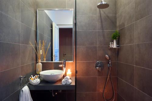 een badkamer met een wastafel en een douche met een spiegel bij Mykonos Chora Residences in Mykonos-stad