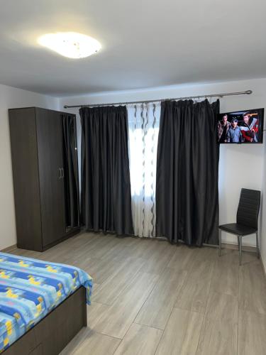 a bedroom with a bed and a window with curtains at Studio Andrei in Râmnicu Vâlcea