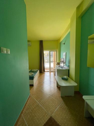 a room with green walls and two beds in it at Vila Senator 1 in Eforie Nord
