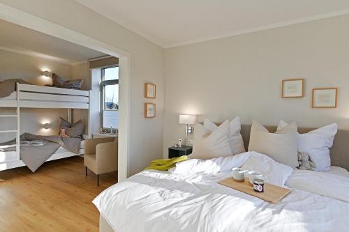 a bedroom with a large white bed and a chair at Helle Deel in Fehmarn