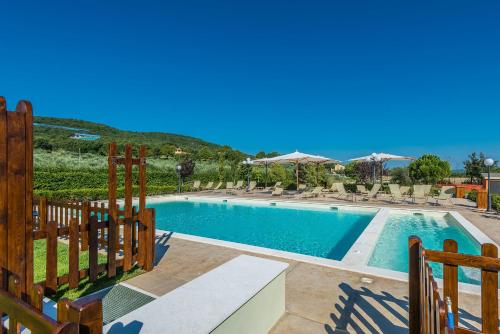 a swimming pool with a wooden fence next to it at Relais Paradiso Resort & Spa in Gualdo Cattaneo