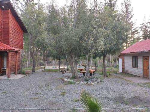 un cortile con tavolo da picnic accanto a una cabina di Cabaña en Recinto con piscina y tinaja a Chillán