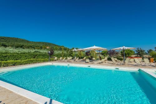 a large swimming pool with chairs and umbrellas at Relais Paradiso Resort & Spa in Gualdo Cattaneo