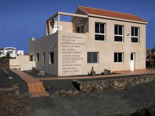 a house with a stone wall in front of it at Casa Oscar - Apartment in El Roque