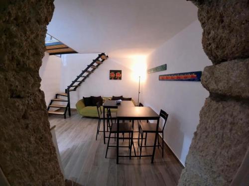 a dining room and living room with a table and chairs at Vecchio Loft in Siracusa