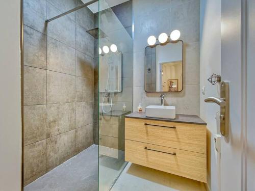 une salle de bain avec un lavabo et une douche avec un miroir dans l'établissement Studio cosy à 30 mètres de la plage, à Antibes