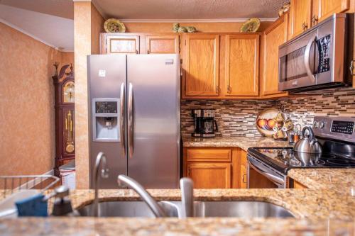 a kitchen with a stainless steel refrigerator and wooden cabinets at CITY & MOUNTAIN VIEW 5 Mins from downtown Gatlinburg in Gatlinburg