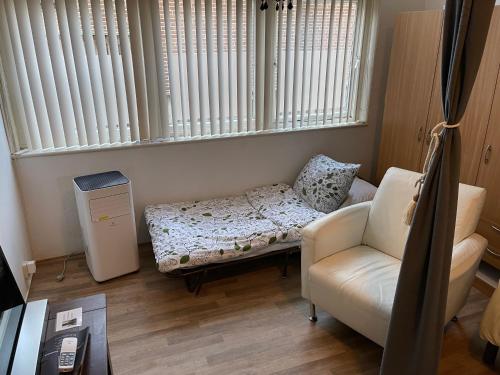 ein Wohnzimmer mit einem Sofa und einem Stuhl in der Unterkunft Studio Dedemsvaart Two nights and more in Dedemsvaart