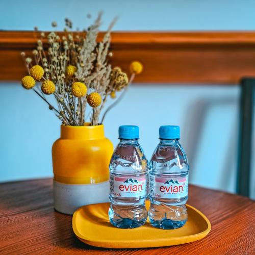 two bottles of water sitting on a yellow plate on a table at Wellness Pension Ametyst in Český Krumlov