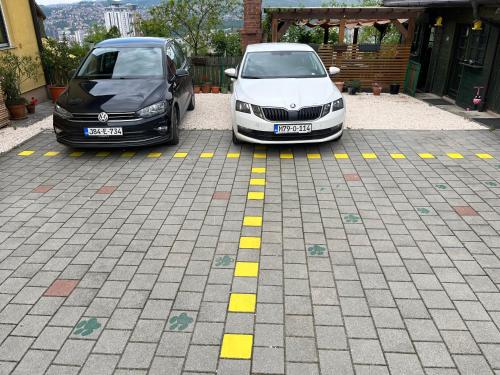 two cars parked next to each other in a parking lot at The View Apartment Sarajevo in Sarajevo