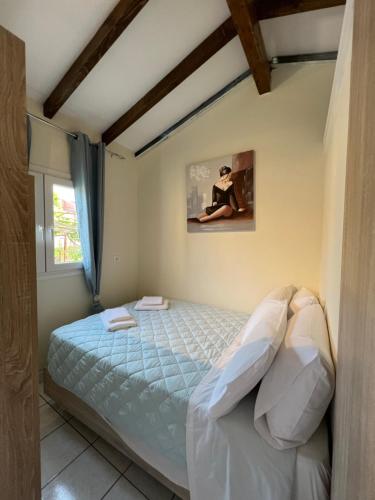 a bedroom with a bed and a window at Vasiliki Little House in Kanoni