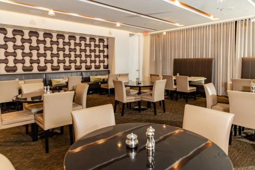 a dining room with tables and chairs and a wall at The Westin Galleria Dallas in Dallas