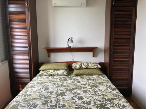 um quarto com uma cama e uma prateleira na parede em Secret Spot Floripa em Florianópolis