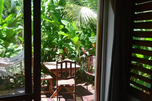 a room with a table and a chair outside a window at Chill Mango in Paracuru