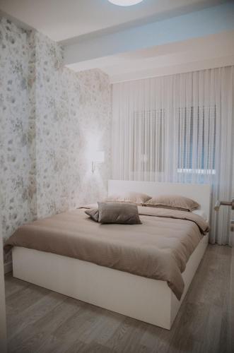 a white bedroom with a large bed in it at Apartman Pelagić in Brčko
