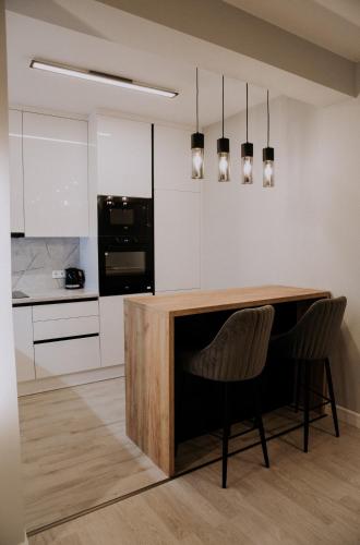 a kitchen with a wooden table and two chairs at Apartman Pelagić in Brčko