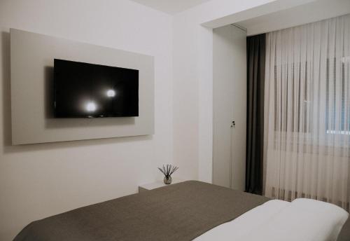a bedroom with a bed and a tv on the wall at Apartman Pelagić in Brčko