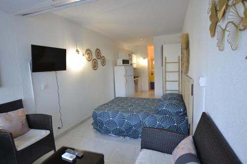 a bedroom with a bed and a couch and a table at Studio Naturiste "JUL'S"Port Nature 401 in Cap d'Agde