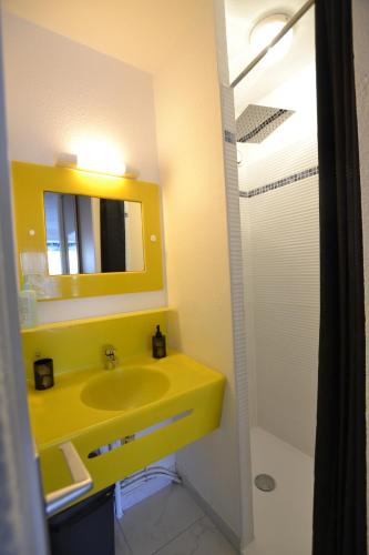 La salle de bains est pourvue d'un lavabo jaune et d'un miroir. dans l'établissement Studio Naturiste 