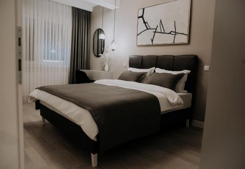 a bedroom with a large bed and a mirror at Apartman Pelagić in Brčko