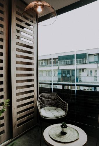 a balcony with a chair and a table and a window at Apartman Pelagić in Brčko