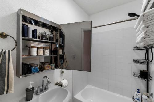 Baño blanco con lavabo y espejo en Prime Location - Walk to Attractions - Sleeps up to 7 People, en Tampa