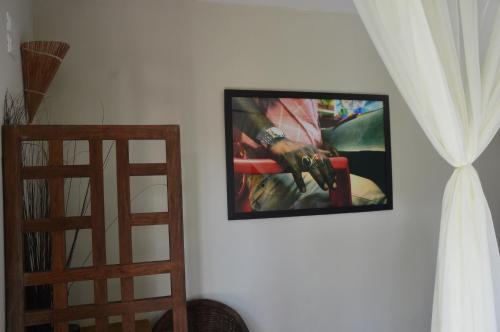 a tv hanging on a wall with a picture of a man with a machine at Chill Mango in Paracuru