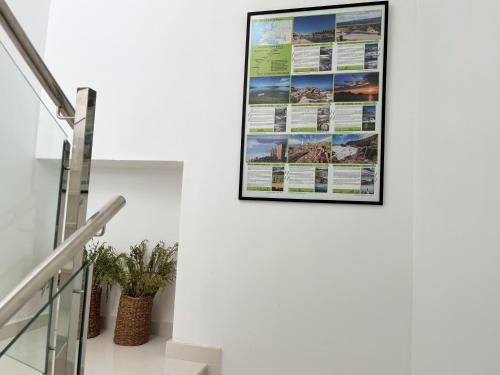 a poster on the wall of a house with stairs at O Refuxio do Náufrago in Camelle