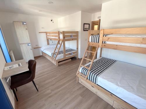 a room with two bunk beds and a desk at O Refuxio do Náufrago in Camelle