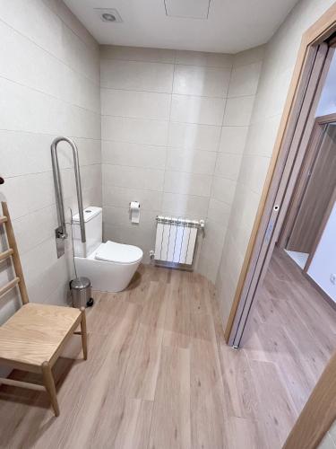 a bathroom with a toilet and a chair in it at O Refuxio do Náufrago in Camelle