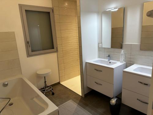 een badkamer met een bad, een wastafel en een bad bij Solesmes 72 in Solesmes