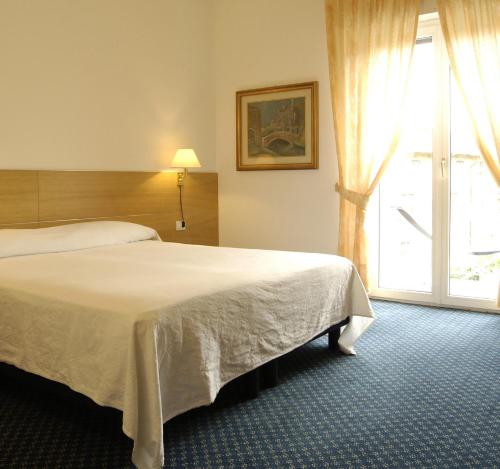 מיטה או מיטות בחדר ב-Albergo Al Caminetto