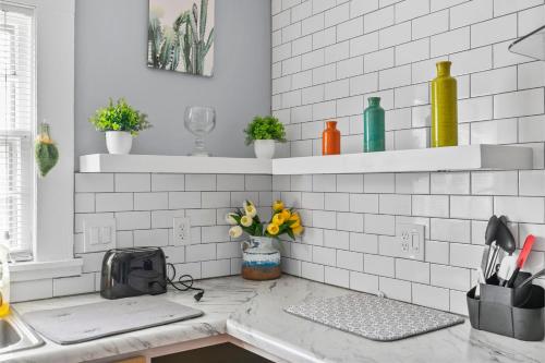 a kitchen with white subway tiles and a counter with flowers at Beautiful Tarrant Home-Minutes to Airport and Downtown in Birmingham