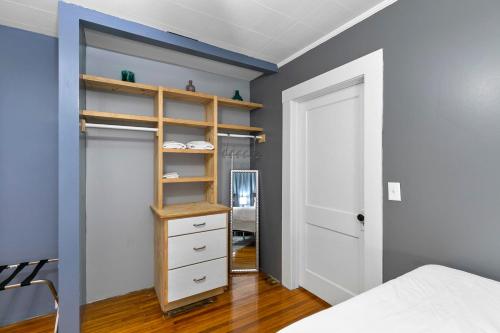 a bedroom with blue walls and a closet with a bed at Beautiful Tarrant Home-Minutes to Airport and Downtown in Birmingham