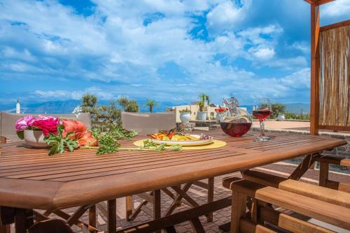 una mesa de madera con 2 copas de vino en Agro Nostro-Euphorbia two bedroom house, en Agios Nikolaos