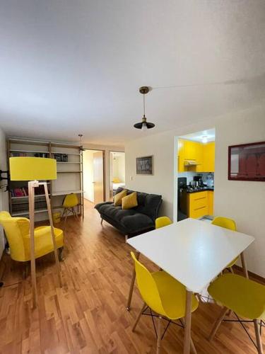 a living room with a white table and yellow chairs at Departamento en Centro Ciudad de México Alameda Reforma in Mexico City