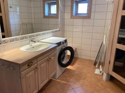 a bathroom with a washing machine and a sink at Tinden in Hemsedal