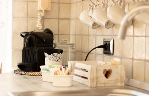 uma bancada com uma máquina de café e uma caixa em Mausida Guest House em Lido di Ostia