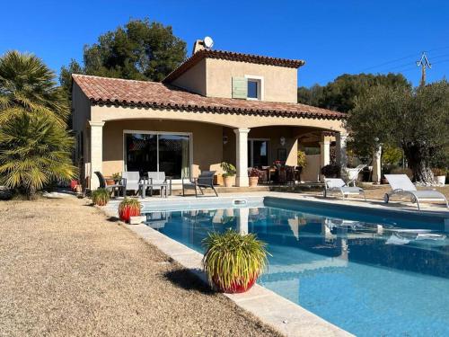 a house with a swimming pool in front of it at Villa et piscine au jardin typique méditerranéen in Carros