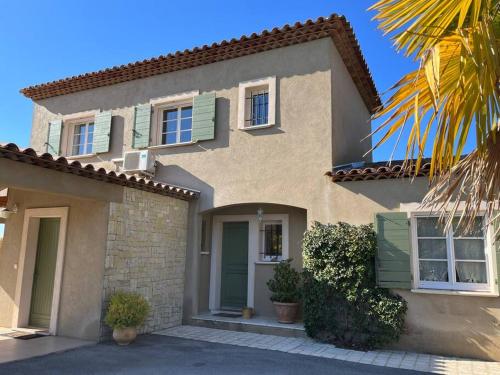a house with a green door and a palm tree at Villa et piscine au jardin typique méditerranéen in Carros