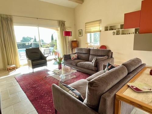 a living room with two couches and a table at Villa et piscine au jardin typique méditerranéen in Carros