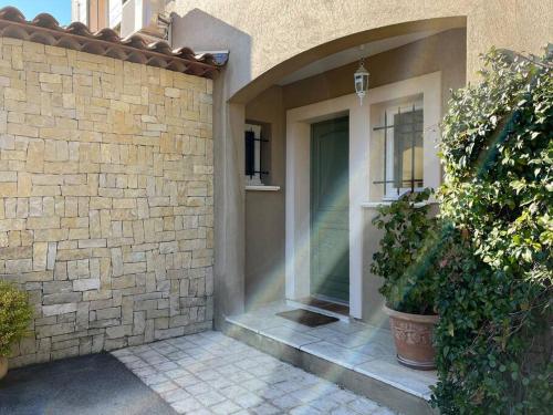 a brick house with a glass door on it at Villa et piscine au jardin typique méditerranéen in Carros