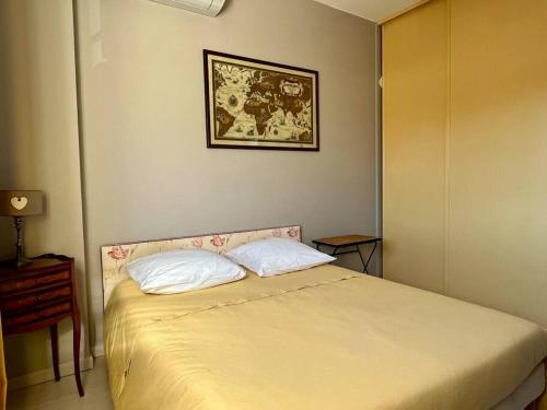 a bedroom with a bed with two pillows on it at Villa et piscine au jardin typique méditerranéen in Carros