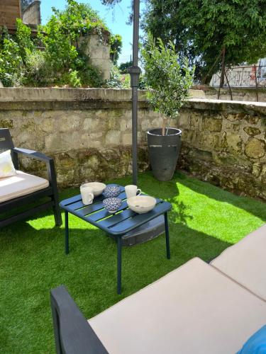uma mesa azul e uma cadeira num quintal em Appt dans maison typique avec jardin privé em Chinon