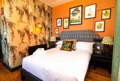een slaapkamer met een groot bed met oranje muren bij The Palm in Bray