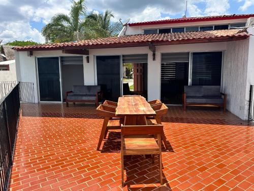 a picnic table on a brick patio in front of a house at bacalar My Love Front Laguna in Bacalar
