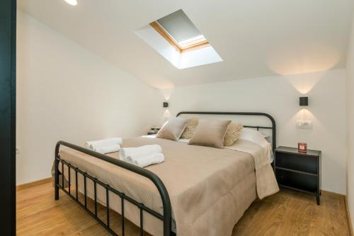 a bedroom with a bed and a skylight at ABI Attic Apartment in Šibenik