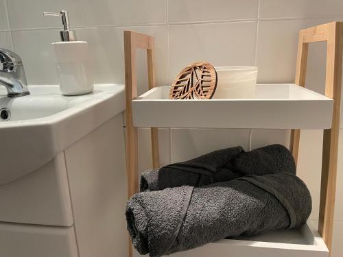 a bathroom with a sink and a shelf with towels at Kasprusie 10 by Homeprime in Zakopane