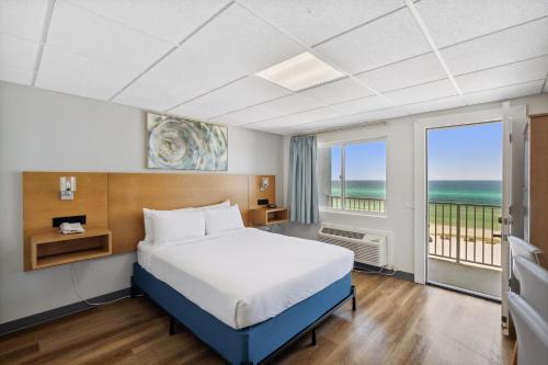 a bedroom with a bed and a view of the ocean at Sugar Sands Beachfront Hotel, a By The Sea Resort in Panama City Beach