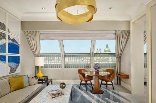 a living room with a table and a large window at Al Habtoor Palace Budapest, Preferred Hotels & Resorts in Budapest